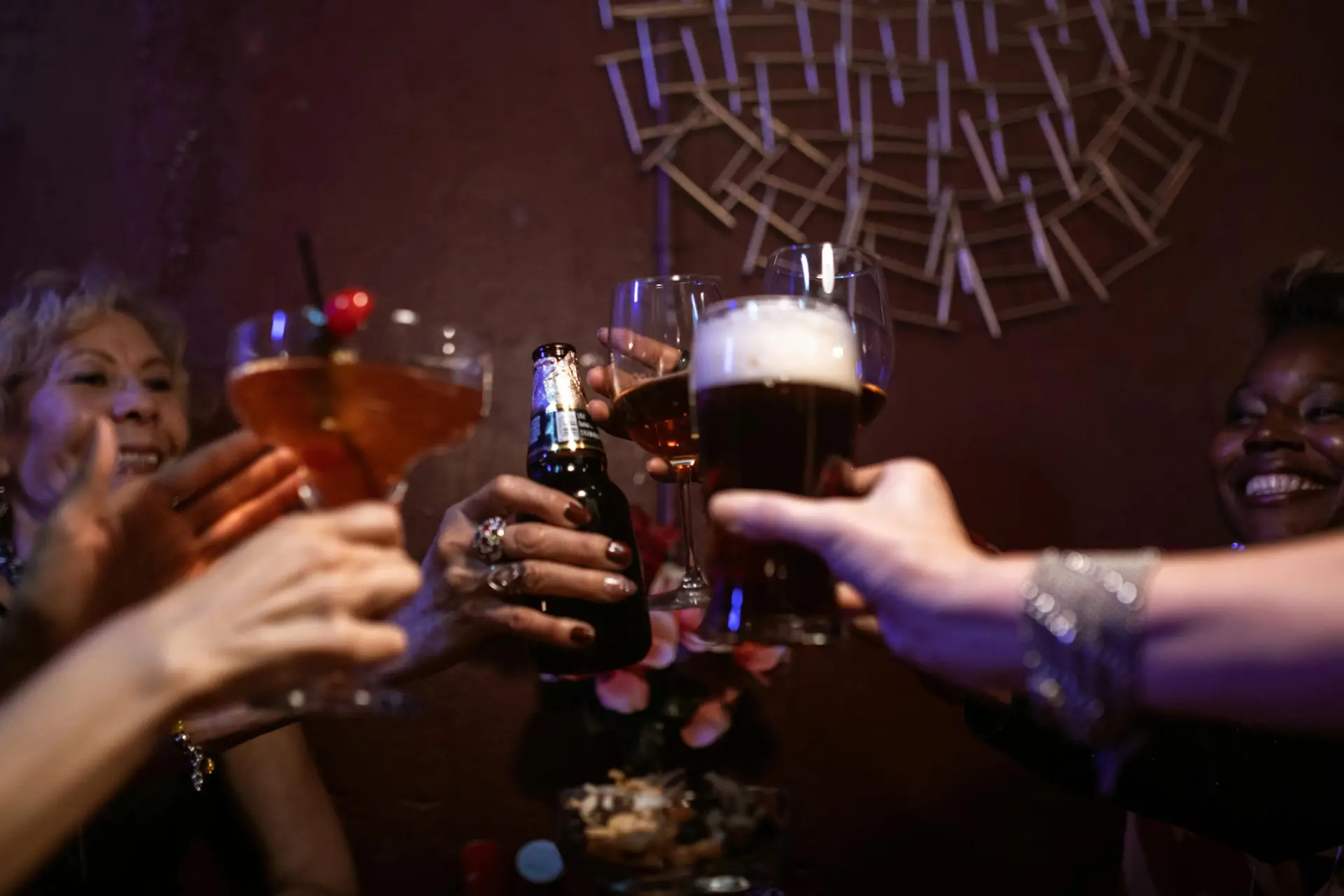A group of friends cheering with drinks in a lively bar setting, capturing the essence of nightlife fun.