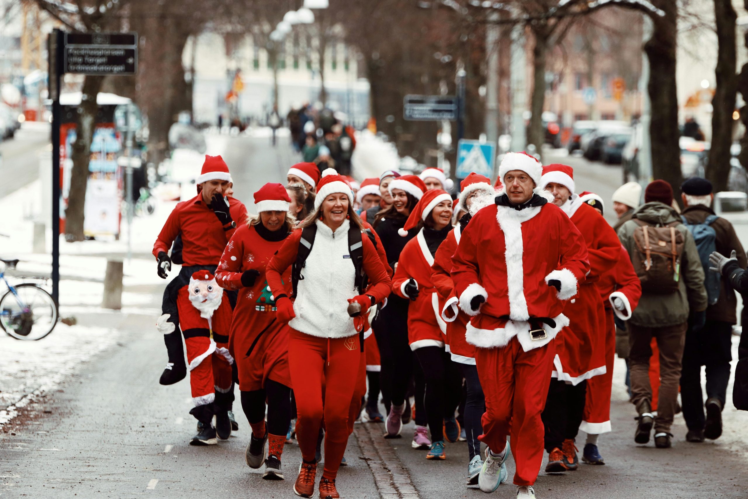 A group of people in Santa costumes enjoys a festive run through snowy Gothenburg, Sweden.