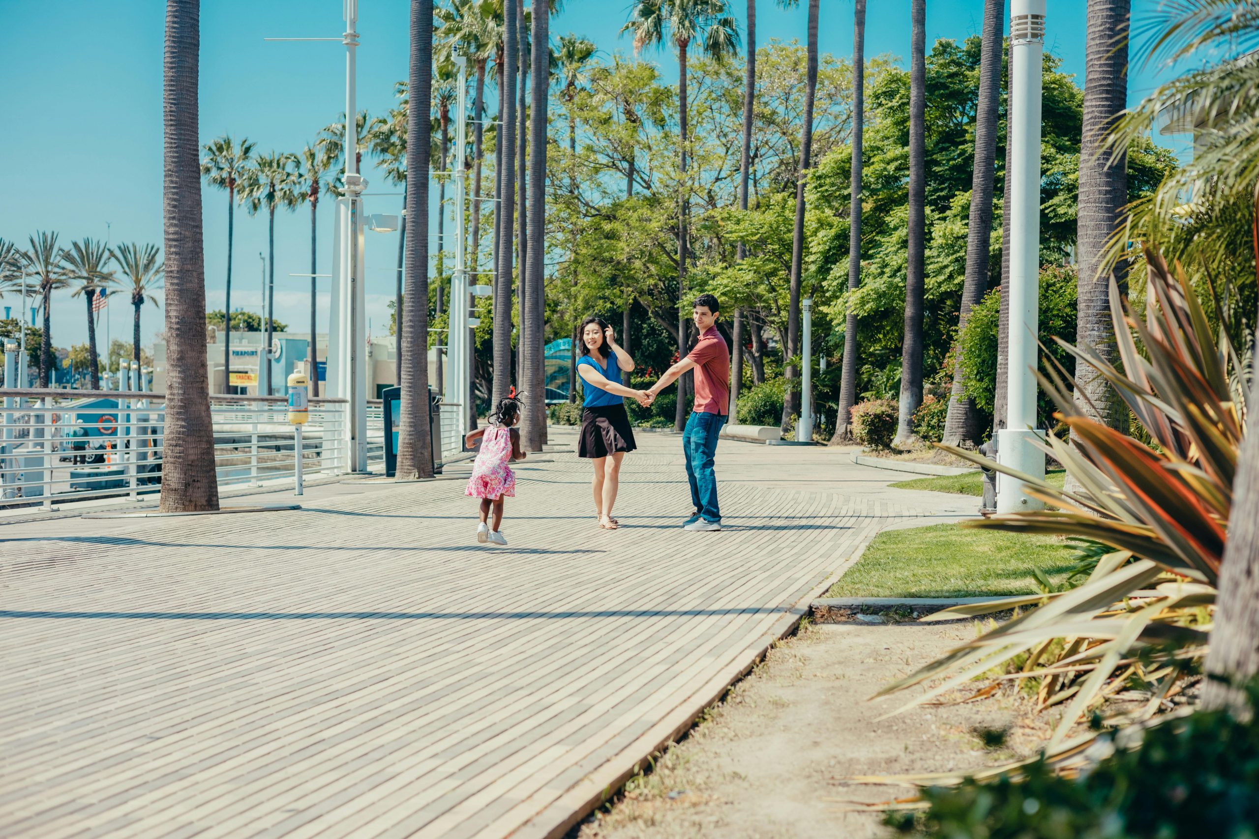 A family having fun walking together on a sunny day in a tropical park.